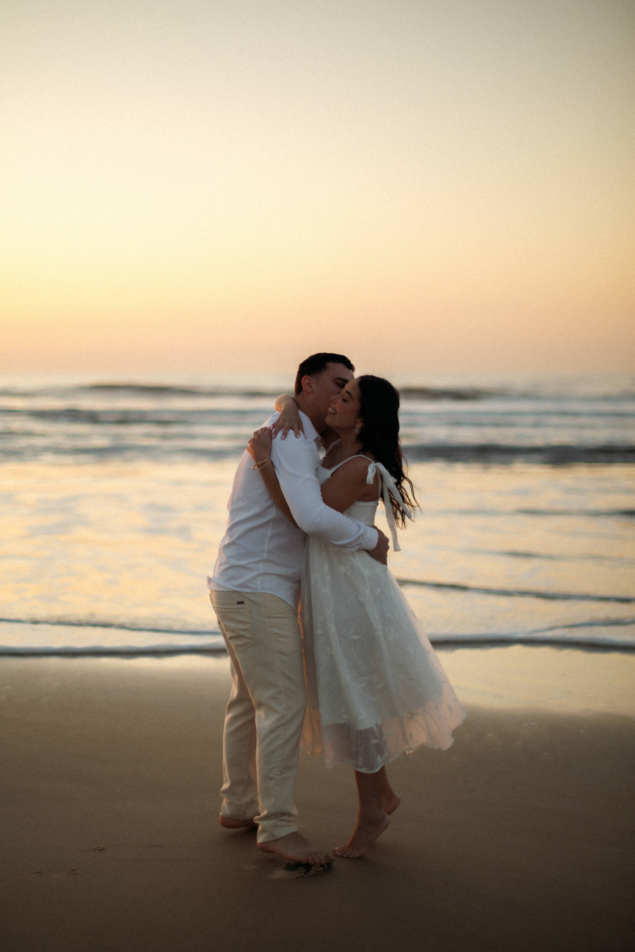 Danielle e Sérgio abraçados ao pôr do sol